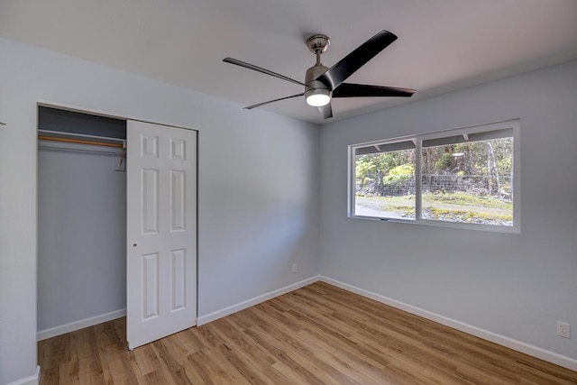 unfurnished bedroom with a ceiling fan, baseboards, light wood-type flooring, and a closet