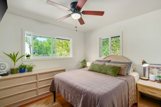 bedroom featuring multiple windows, light wood-type flooring, and ceiling fan