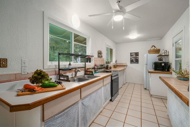 kitchen with ceiling fan, stainless steel electric stove, sink, and light tile patterned flooring