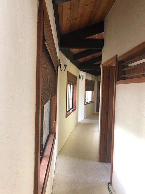 hall featuring wooden ceiling and lofted ceiling with beams