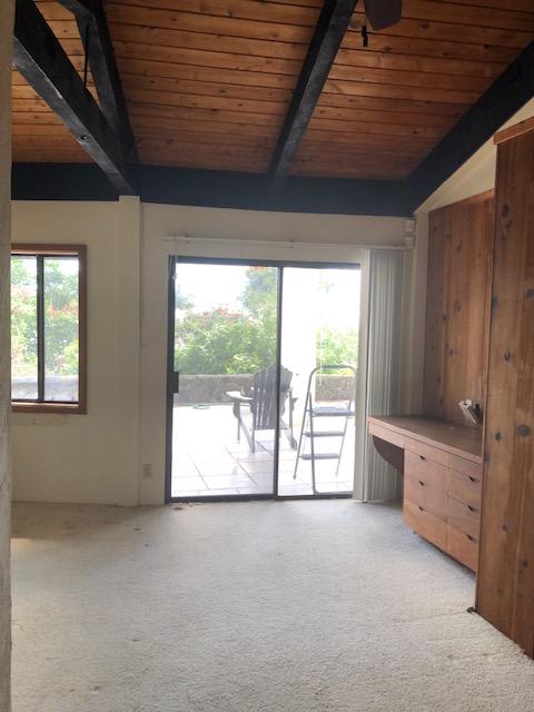 interior space with wood ceiling, light colored carpet, and vaulted ceiling with beams