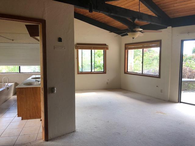 empty room with a wealth of natural light, wood ceiling, light tile patterned flooring, and lofted ceiling with beams