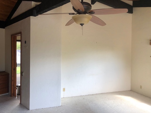 unfurnished room featuring vaulted ceiling with beams, ceiling fan, and carpet