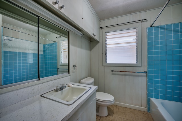 full bathroom featuring tiled shower / bath, toilet, a textured ceiling, and vanity