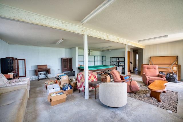 living room featuring billiards, a textured ceiling, and concrete floors