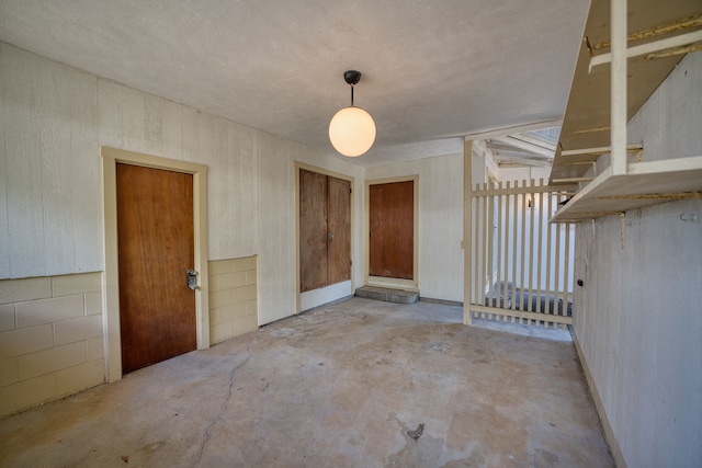 spare room with a textured ceiling and concrete flooring