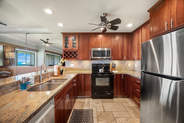 kitchen with hanging light fixtures, stainless steel appliances, ornamental molding, sink, and ceiling fan