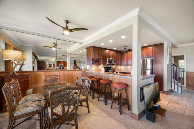 dining room with crown molding, ceiling fan, and sink