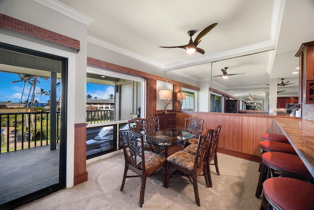 dining space with crown molding, ceiling fan, and carpet flooring