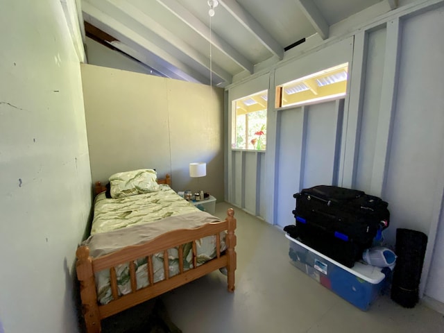 bedroom with concrete floors and lofted ceiling with beams