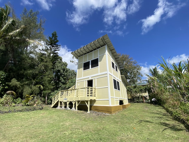 back of property featuring a lawn and stucco siding