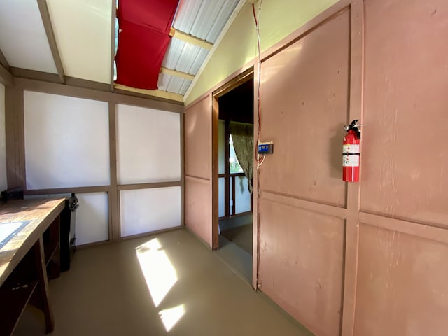 miscellaneous room with lofted ceiling and concrete flooring