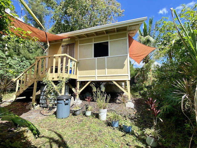 back of property with a deck and stairway