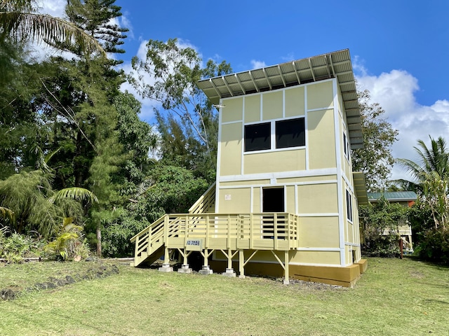 back of property featuring a yard and stucco siding