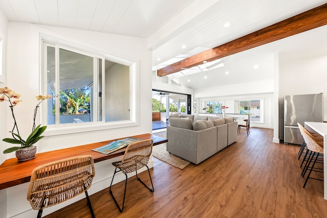 living room with a wealth of natural light, lofted ceiling with beams, and wood-type flooring