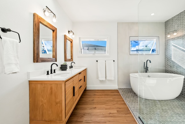 bathroom featuring hardwood / wood-style flooring, a tub, and vanity