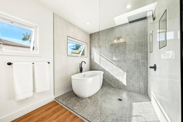 bathroom featuring shower with separate bathtub and hardwood / wood-style floors