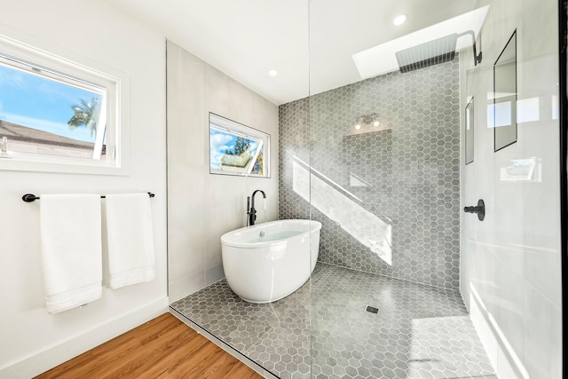 bathroom featuring a wealth of natural light, wood finished floors, and walk in shower