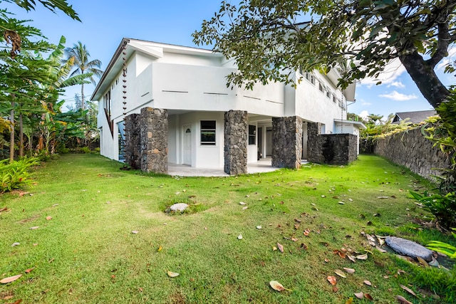 rear view of house featuring a yard