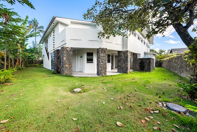 back of house with a lawn, a patio area, fence, and stucco siding