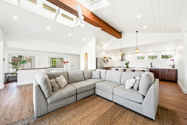 living room featuring beamed ceiling, ceiling fan, high vaulted ceiling, and hardwood / wood-style flooring