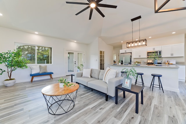 living room featuring lofted ceiling, ceiling fan, and light hardwood / wood-style floors