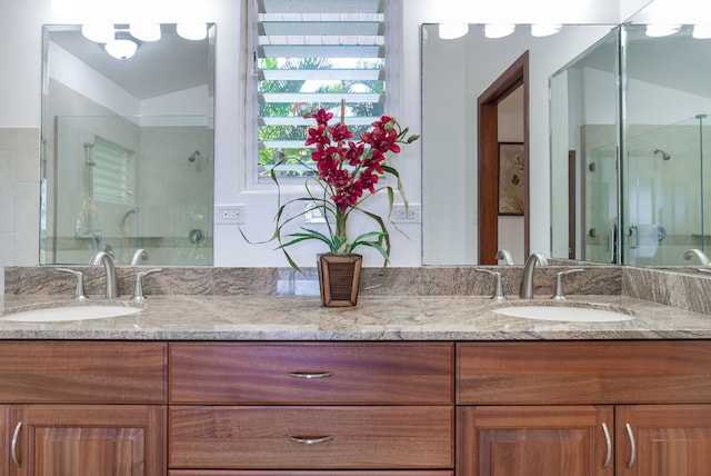 bathroom featuring a shower with shower door, vanity, and vaulted ceiling