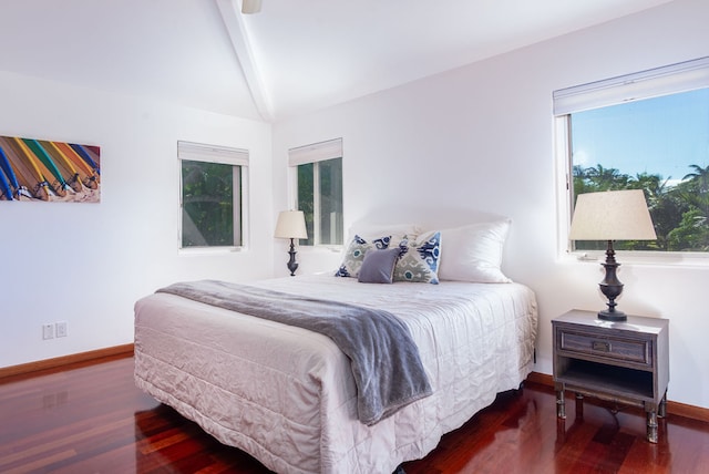 bedroom with lofted ceiling with beams, multiple windows, and wood-type flooring