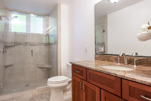 bathroom featuring toilet, vanity, tile patterned floors, and a shower with shower door