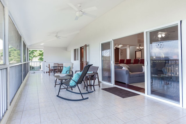 sunroom featuring vaulted ceiling and ceiling fan with notable chandelier