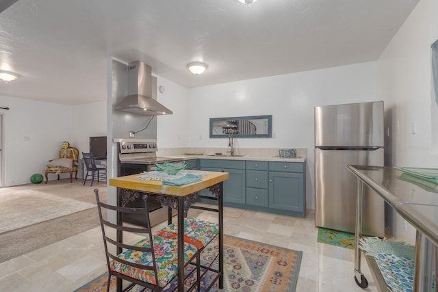 kitchen featuring light tile patterned floors, sink, stainless steel refrigerator, and wall chimney exhaust hood