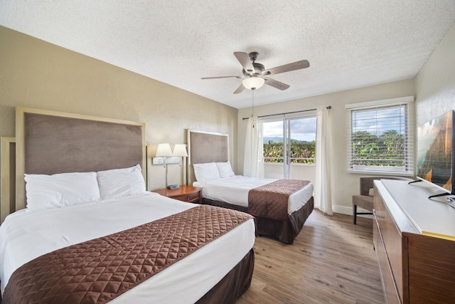 bedroom featuring hardwood / wood-style floors, ceiling fan, and a textured ceiling