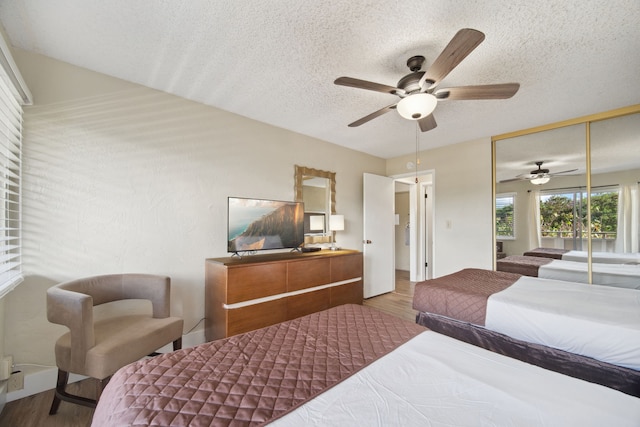 bedroom featuring a textured ceiling, hardwood / wood-style flooring, ceiling fan, and a closet