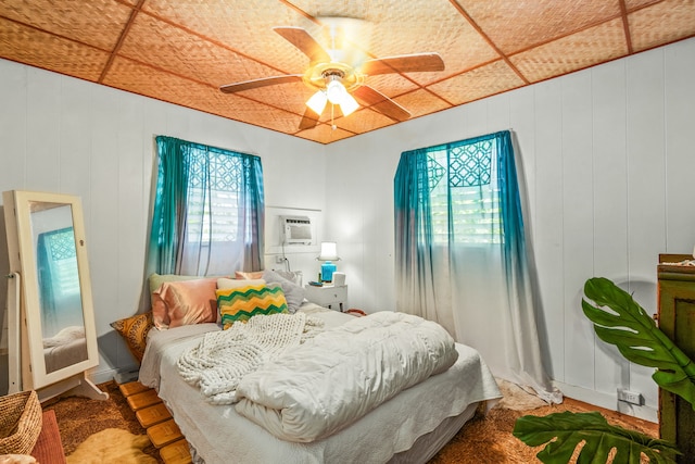 bedroom with ceiling fan and a wall mounted air conditioner