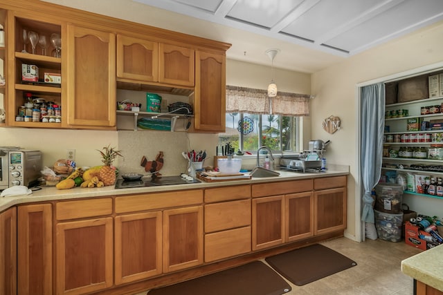 kitchen with hanging light fixtures, light tile patterned floors, black electric cooktop, and sink