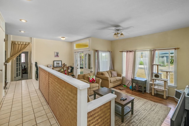 living room with light wood-type flooring, a wealth of natural light, and ceiling fan