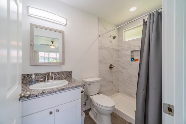 bathroom featuring toilet, walk in shower, ceiling fan, and vanity