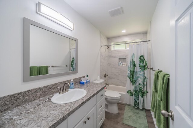 full bathroom with vanity, toilet, wood-type flooring, and shower / bath combo