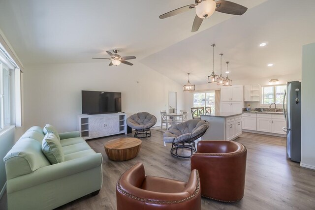 living room with vaulted ceiling, wood-type flooring, and ceiling fan