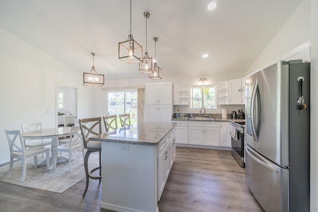 kitchen featuring vaulted ceiling, open shelves, appliances with stainless steel finishes, and a sink