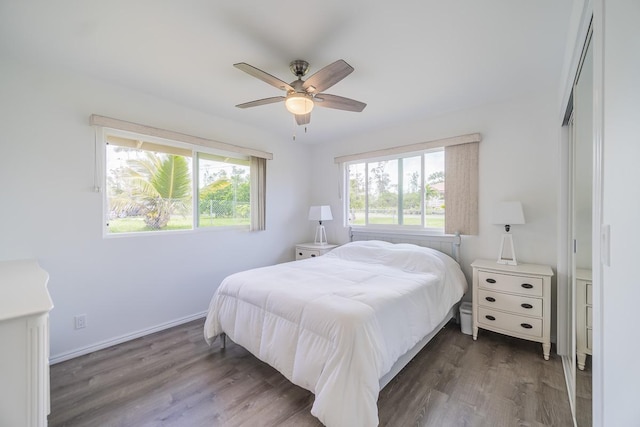 bedroom featuring dark wood-type flooring, baseboards, and a ceiling fan