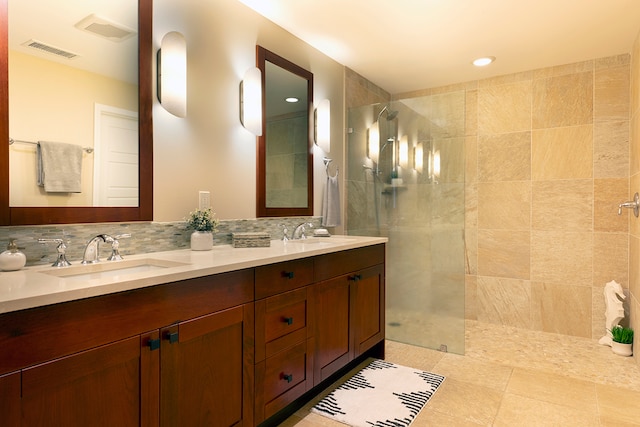 bathroom featuring tiled shower, vanity, tile patterned flooring, and tasteful backsplash