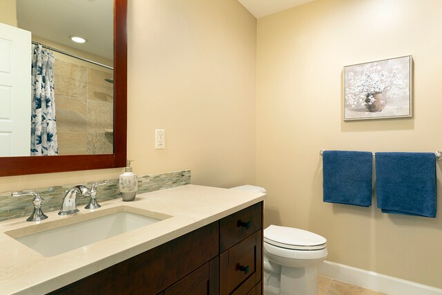 bathroom with tile patterned flooring, curtained shower, vanity, and toilet