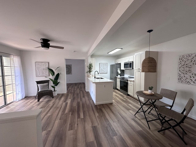 kitchen featuring ceiling fan, hanging light fixtures, wood-type flooring, white cabinets, and appliances with stainless steel finishes