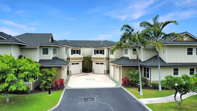 multi unit property featuring a garage and a front yard