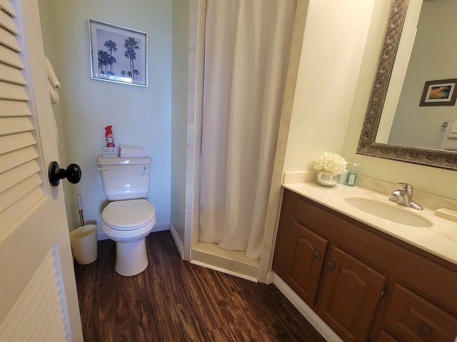 bathroom featuring toilet, hardwood / wood-style floors, vanity, and curtained shower