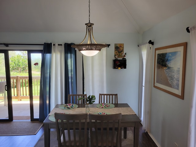 dining space featuring hardwood / wood-style floors and vaulted ceiling