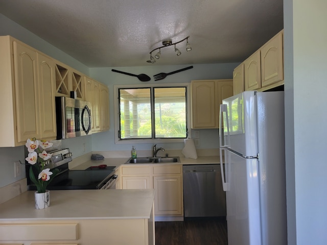 kitchen featuring dark hardwood / wood-style floors, sink, rail lighting, a textured ceiling, and stainless steel appliances