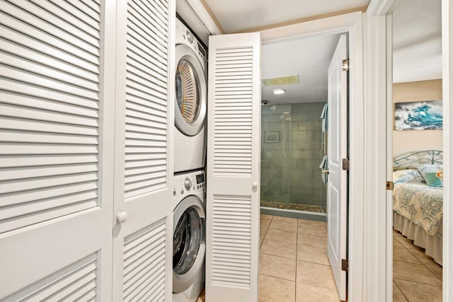 washroom featuring stacked washer and dryer and light tile patterned floors