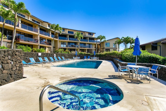 view of swimming pool with a hot tub and a patio